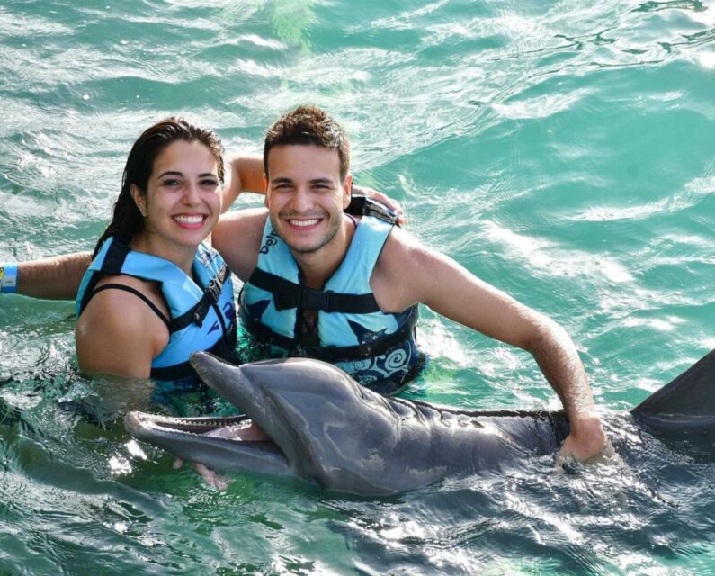 couple swim with dolphins in isla mujeres