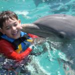 boy has activities day in dolphin discovery cancun