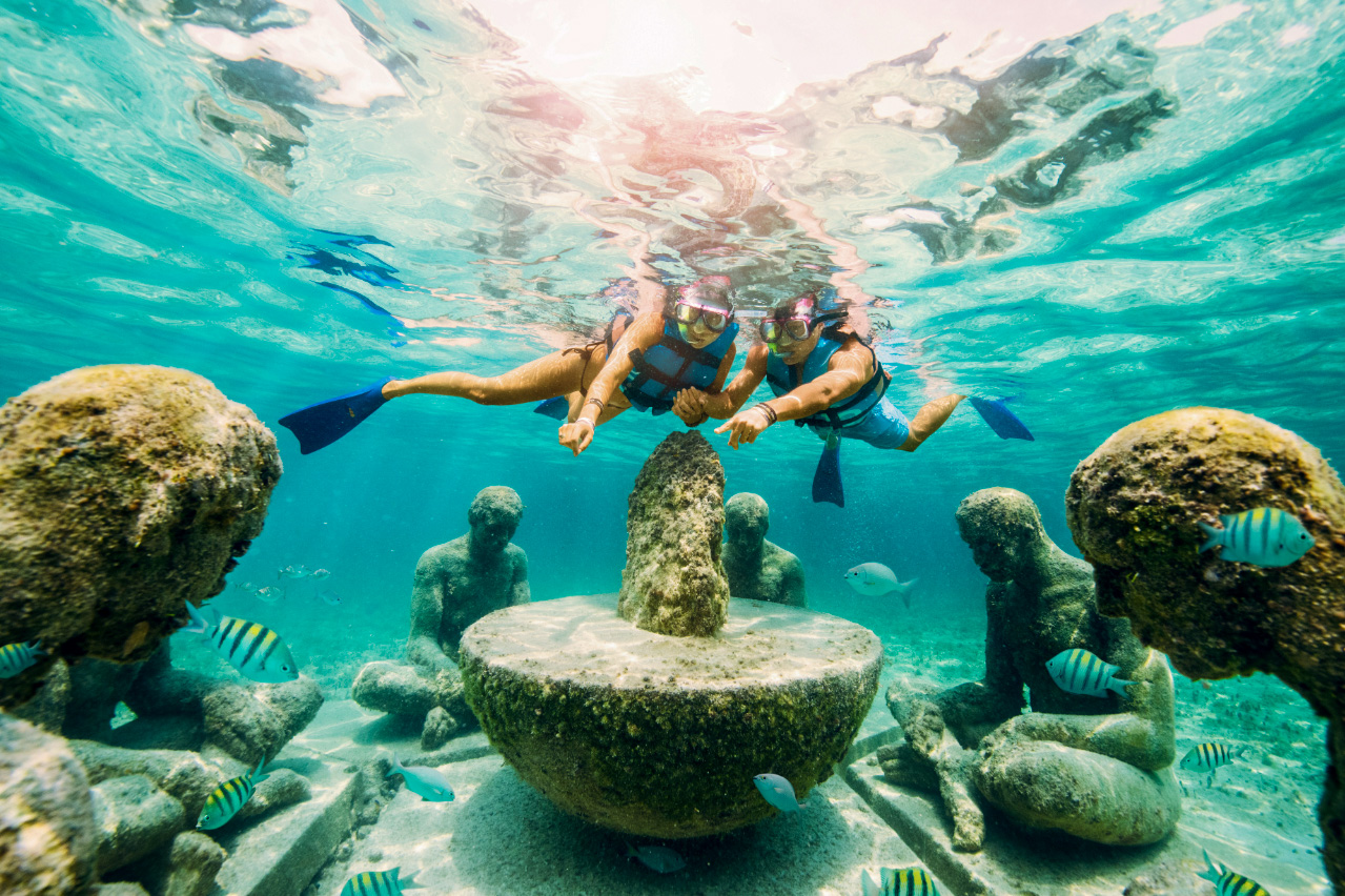 couple snorkeling at the underwater art museum in cancun