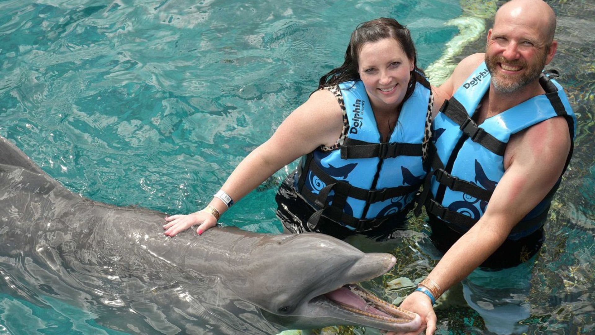 couple swimming with dolphins in cozumel