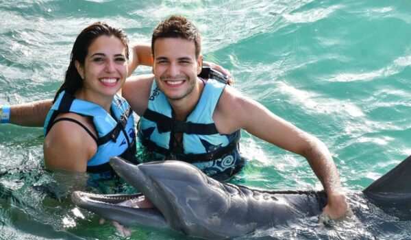 couple swim with dolphins in isla mujeres