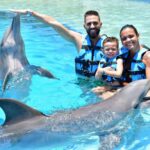family having fun with dolphins in dolphin discovery playa del carmen